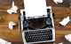 macchina da scrivere con fogli sul tavolo accartocciati